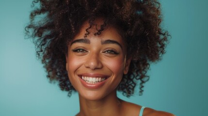 A smiling afro woman lights up a studio shot on a blue background