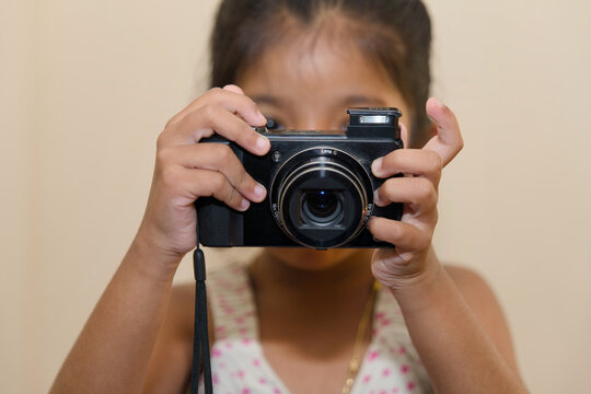 Little girl taking a picture with a vintage camera Focus on the camera