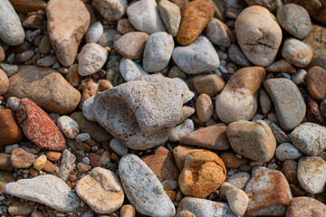Gray sand and stones close-up on the beach. Stone in the foreground.