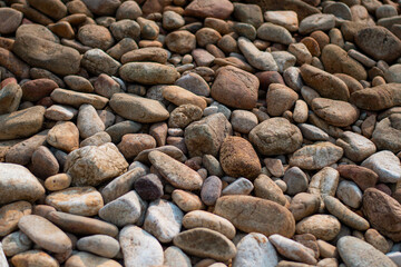 Gray sand and stones close-up on the beach. Stone in the foreground.