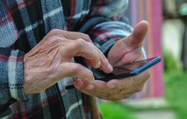 smartphone in the hands of an old man. old man using smartphone