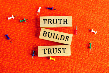 Truth builds trust symbol. Concept words Truth builds trust on wooden blocks on a red background....