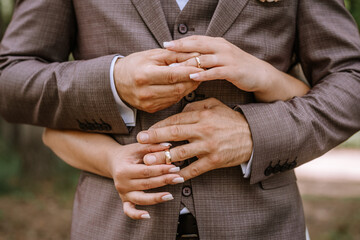 Valmiera, Latvia- July 28, 2024 - A close-up of a newlywed couple's hands, showcasing their wedding...