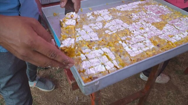 indian sweets making and swees placed empty rectangle tray closeup view