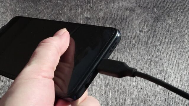 Person plugging charging to smartphone via Type-C cable, then disconnecting