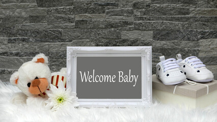 Invitation or greeting card motif: teddy bear with gift, flowers, baby shoes and the text Welcome Baby.