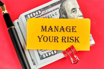 Business and manage your risk concept. Concept word Manage your risk on a sticker lying on dollar...