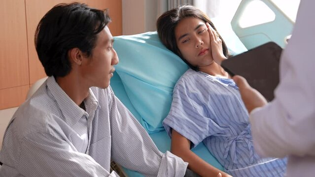 Asian medical obstetrician doctor diagnosis examines reports using tablet for threatened miscarriage symptoms to patient woman while husband holding hands and accepts treatment procedure recovery