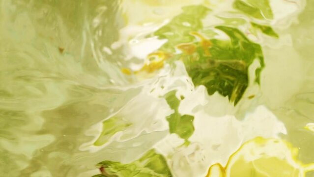 Abstract blur water surface motion, splash, ripples, lemon fruit and mint leaves