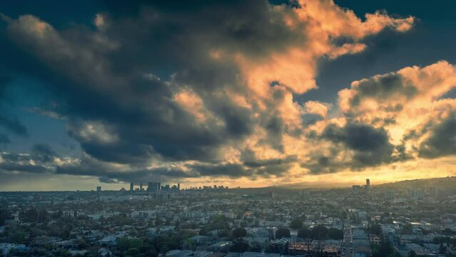 Storm clouds moving over city of Los Angeles skyline at sunset. Aerial hyperlapse timelapse view.