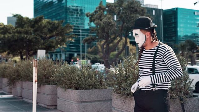Mime, creativity and man in city with paint on face for performance, action and comedy outdoor. Artist, art and comic acting in urban street, drama or show for entertainment with mask for fun
