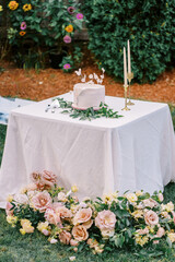 Elegant wedding cake adorned with flowers on a garden table