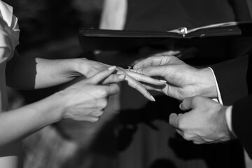 Close-up of bride and groom exchanging rings during wedding ceremony - obrazy, fototapety, plakaty