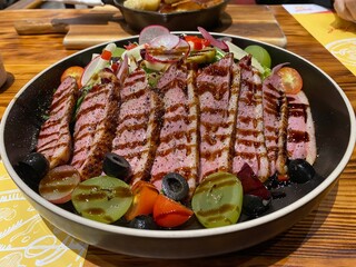 duck grilled salad serving in dark plate on wooden table