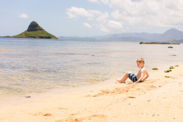 Boy playing on the beach near island