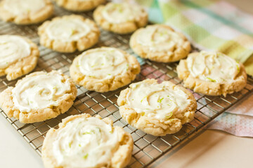 Frosted cookies with lime zest cooling on a wire rack