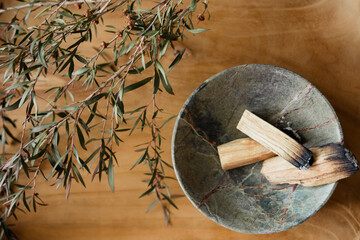 Palo Santo sticks in marble bowl with manuka on wooden background