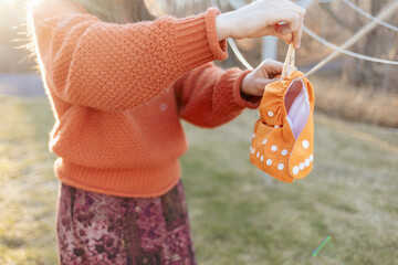 Women hanging cloth diaper on laundry line with beautiful lighting
