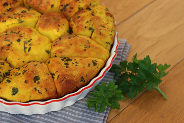 Turmeric curcuma and parsley bread . Healthy turmeric Bread in a cake pan on a gray striped napkin on wooden table
