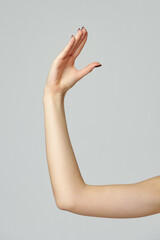 Young woman hand gesture on gray background