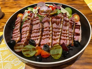 duck grilled salad serving in dark plate on wooden table