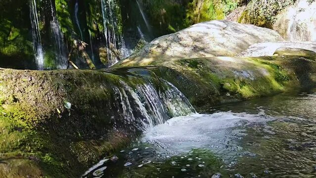 This footage captures the essence of natural tranquility, inviting viewers to immerse themselves in the peaceful ambiance of the forest. slowmotion of a little waterfall