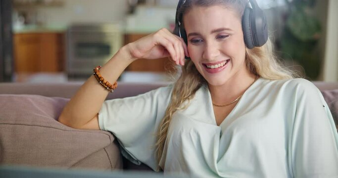 Happy woman, laptop and headphone for streaming online, watching movies or entertainment with technology in living room. Female person, headset and computer with smile, social media or music on sofa