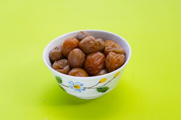 Pickled plums on green background.