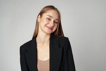 Young Woman in Black Jacket Posing to Camera against gray background