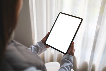 Mockup image of a woman holding digital tablet with blank desktop screen while sitting on a sofa at home - 786900039