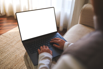 Mockup image of a woman working and typing on laptop computer with blank white desktop screen at home - 786900085