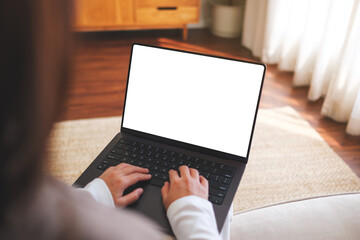 Mockup image of a woman working and typing on laptop computer with blank white desktop screen at home - 786900098