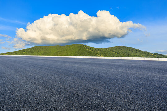 Asphalt road and green mountain with sky clouds background