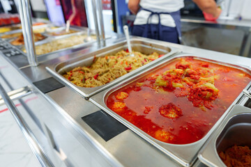 Bustling Cafeteria Serving Line During Lunchtime Offering a Variety of Dishes - 786902417