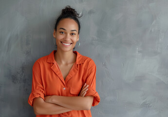 Radiant Woman with Bright Smile and Arms Crossed in Casual Orange - 786904404