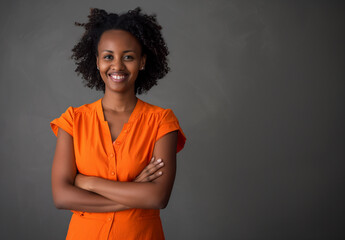 Smiling Woman in Orange with Arms Crossed Exuding Confidence and Joy - 786904841