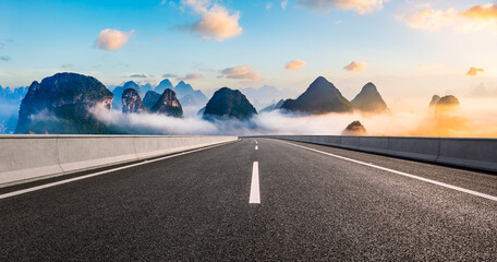 Asphalt highway road and karst mountain with sky clouds at sunrise. Panoramic view. - obrazy, fototapety, plakaty