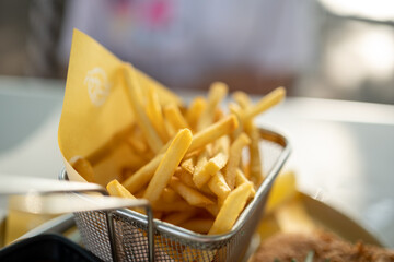 French fries wrapped in paper on the dining table