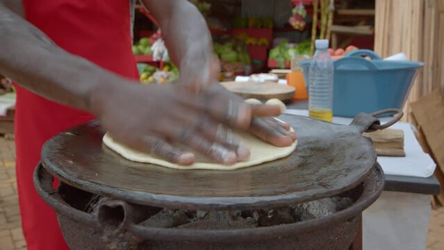Cropped View Of Ugandan Man Making Egg Street Food Dish Called Rolex. Close-up Shot