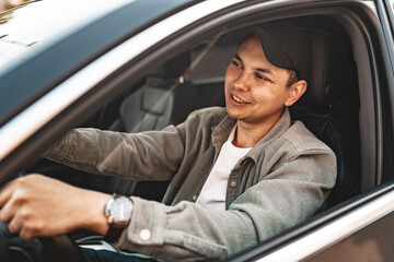 Young smiling man sitting in a car with open window - 786921872