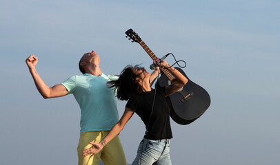 Free music. Couple enjoy music, move emotionally. Two carefree overjoyed people singing outdoor. Crazy music. Carefree couple sing hold mic and guitar. Freedom and music. - 786922074