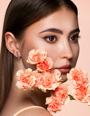 Beauty studio portrait of young beautiful woman in peach tones.