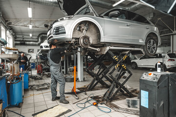 Auto mechanic repairs running gear of a car in car service - 786923082