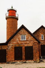 A brick building featuring a lighthouse atop, against the backdrop of the sky