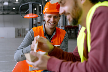 Attractive, smiling workers holding lunch boxes, eating lunch, food, chatting with each other - obrazy, fototapety, plakaty