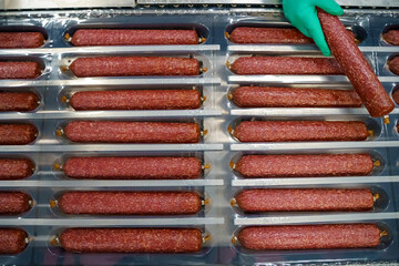 Salami sausage production at a meat factory. Pork and beef sausage salami industry