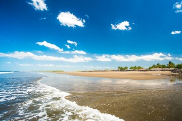 "Paso Caballos" Beach. Chinandega, Nicaragua. Beautiful summer day at relaxing tropical beach. Blue sky, soft waves kissing the shoreline.