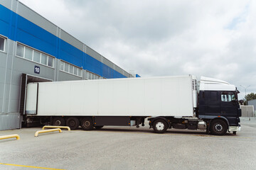 Truck parked near cargo terminal, loading goods on street near warehouse. Concept of transportation
