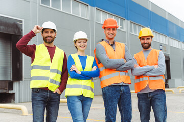 Confident successful managers, workers, men and woman wearing hard hats, vests and work wear