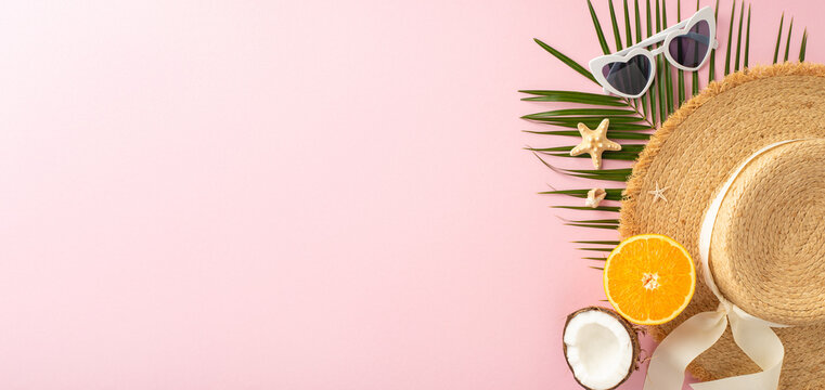 A vibrant summer display featuring a straw hat, sunglasses, tropical fruits, and palm leaves on a pink backdrop, perfect for vacation or travel themes